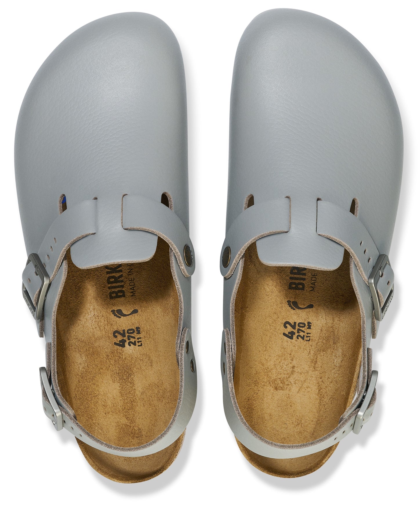 A pair of light gray, round-toed, backless clogs with buckled straps over the bridge and around the heel, featuring tan cork insoles with the text 'BIRK', '42', and '270' printed in black.