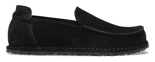 A black suede loafer-style shoe with a low heel and a thick, textured sole.