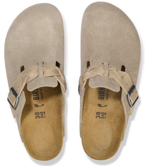A pair of taupe suede slip-on shoes with a braided strap and silver buckle across the top, featuring a contoured footbed with size 38 markings.