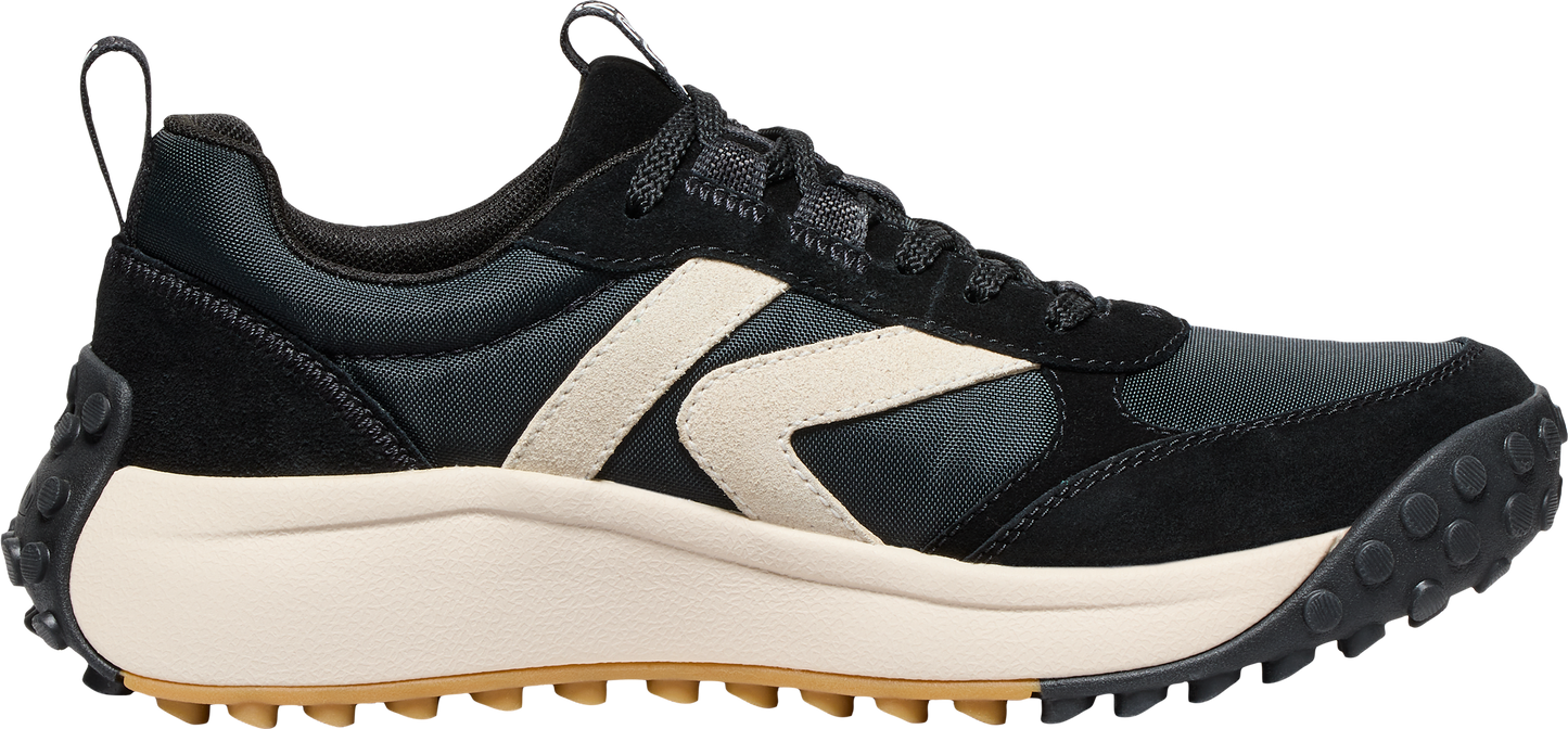 Black sneaker with beige accent and thick beige sole with black tread.
