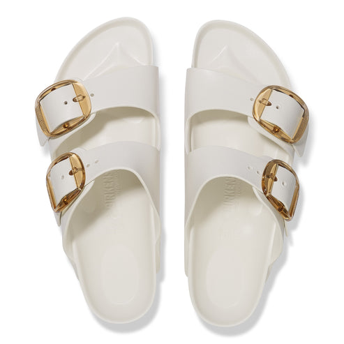 White sandals with large gold buckles.