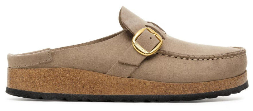 A tan suede mule clog with a thick cork midsole and a black rubber outsole featuring a gold-toned side buckle strap closure.