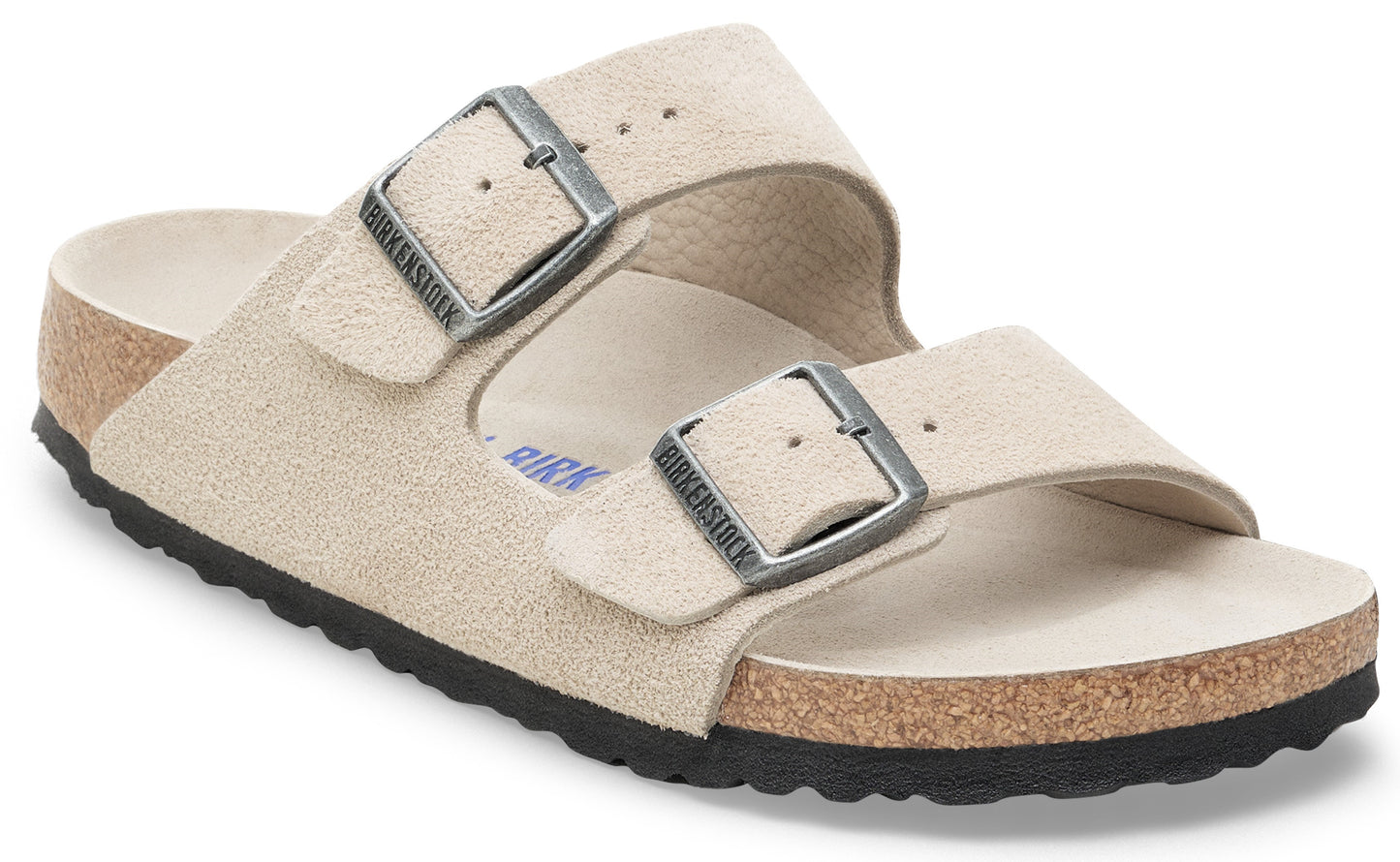 Beige suede sandal with two adjustable straps and silver buckles.