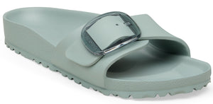 A pale green slide sandal with a large, transparent buckle.