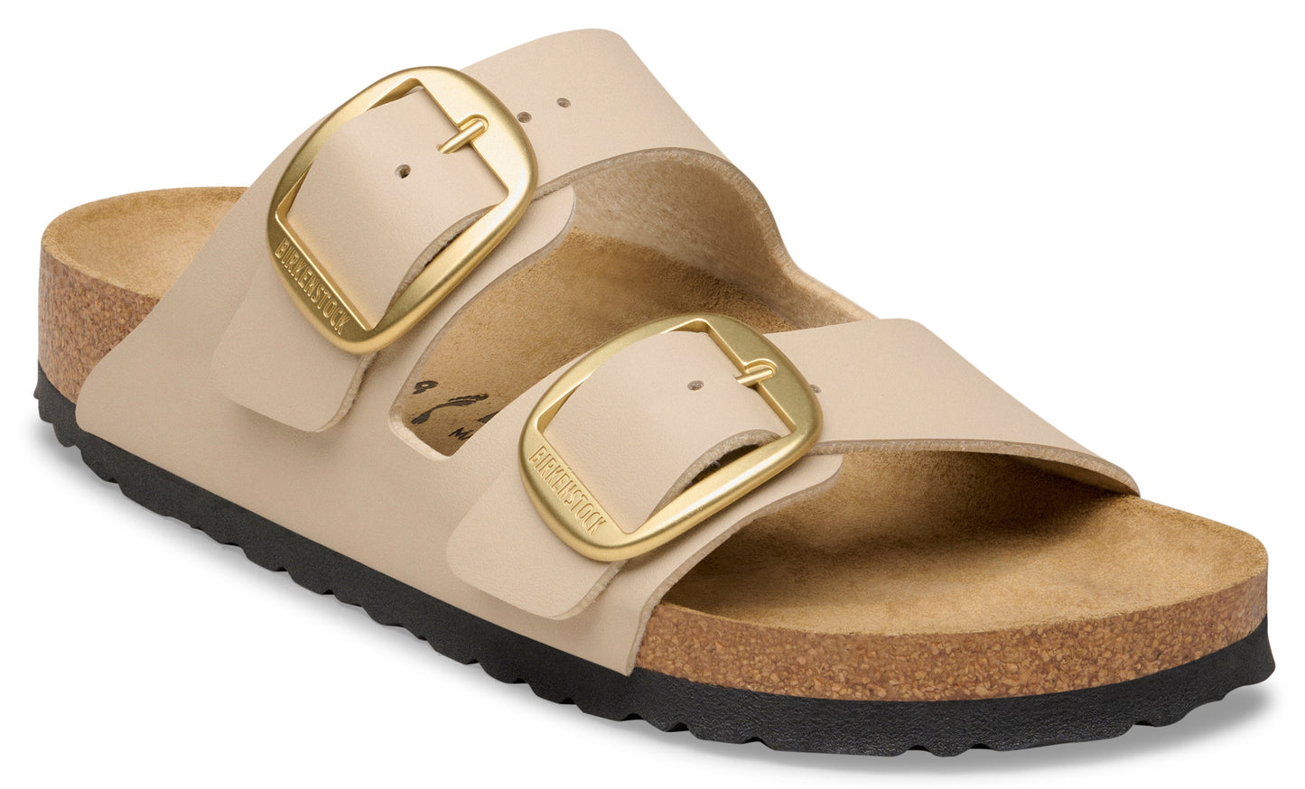 Sandals with two adjustable straps, each with a large gold buckle, atop a dark sole and cork footbed.
