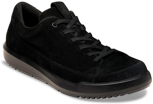 A low-top, black suede sneaker with matching black laces, a padded collar, and a thick, dark grey rubber sole with a textured tread.