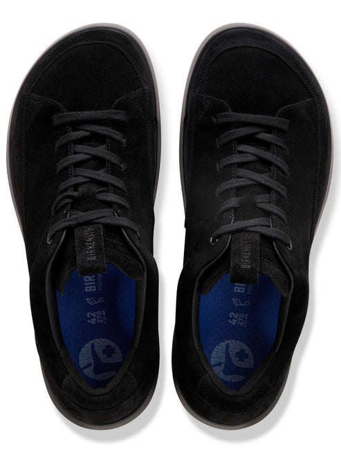 A pair of top-down black suede sneakers with laces, showing blue footbeds imprinted with size 42 and a logo of a foot.