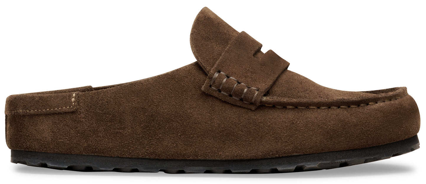 A brown suede mule-style loafer with a penny loafer strap detail and a thick, textured black rubber sole.
