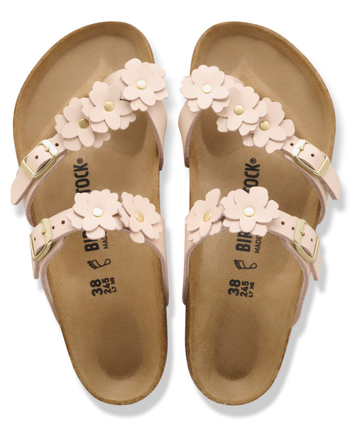 Pair of pink, buckle strap sandals adorned with a flower embellishment.