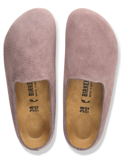 A pair of mauve suede slip-on shoes with cork footbeds, showing the text "BIRKENSTOCK" and size "38" inside.