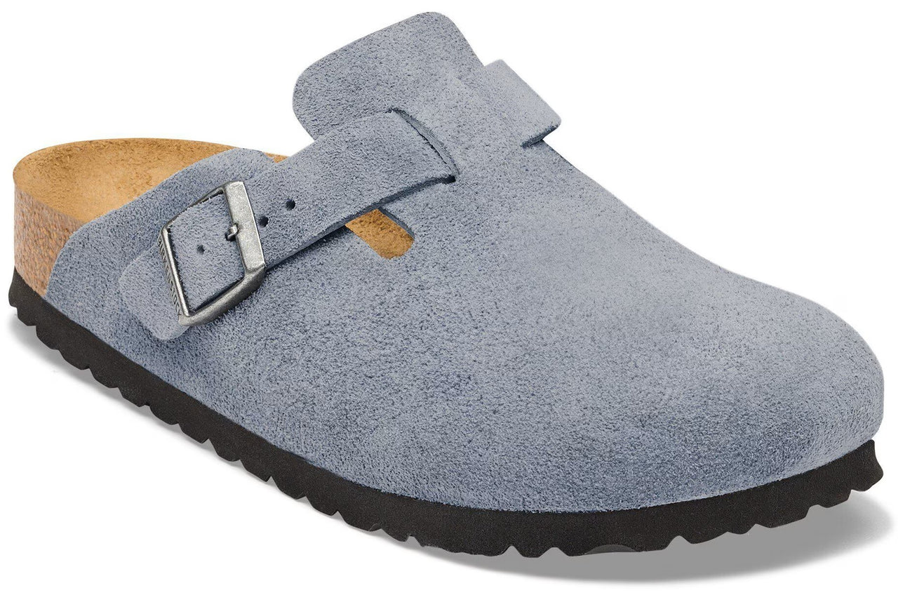 A light blue suede clog with an adjustable metal buckle strap, a cork footbed, and a thick, ridged black rubber outsole.