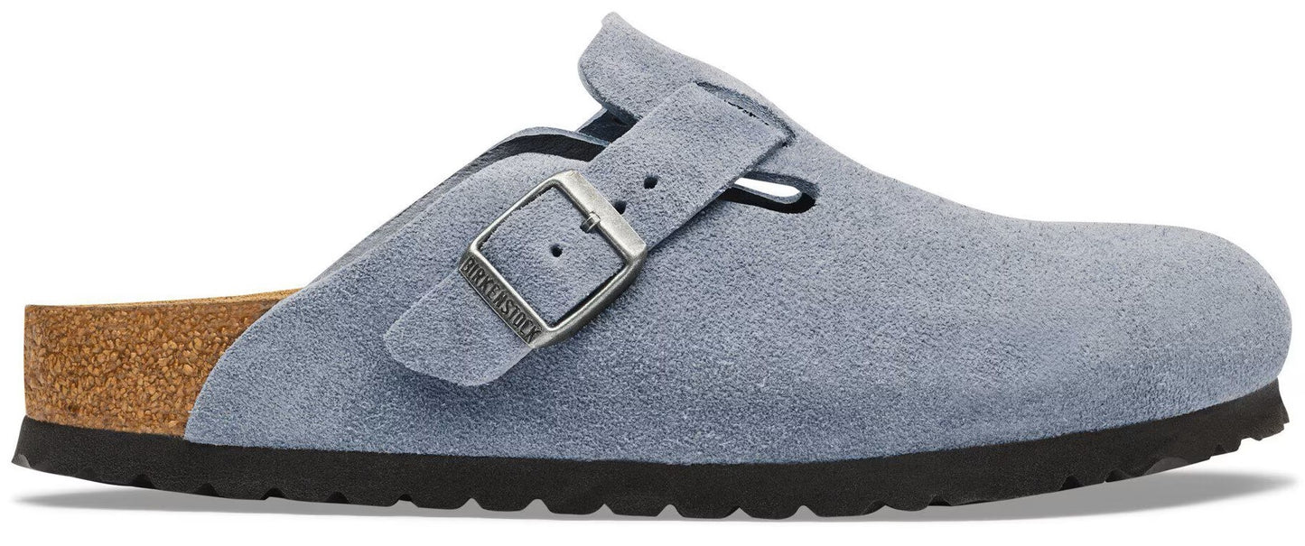 A light blue suede Boston style clog with an adjustable metallic buckle strap, a cork footbed, and a thick black serrated rubber sole.