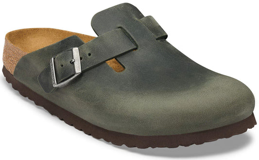 A slip-on clog with a dark olive green leather upper, a silver metal buckle, a cork footbed, and a thick brown treaded rubber sole.