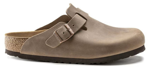 Taupe clog shoe with a buckle strap.