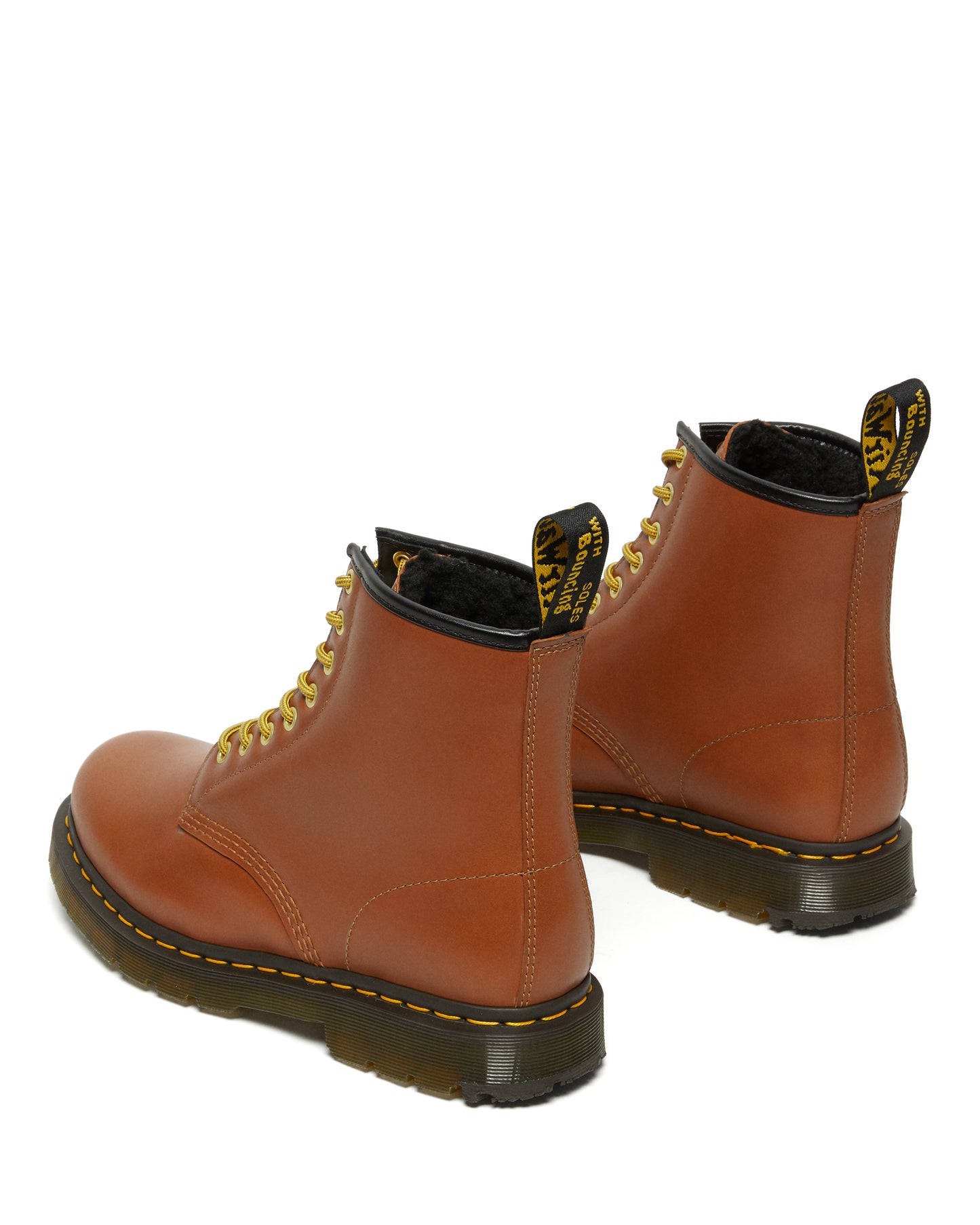 Two brown leather work boots with yellow laces and thick black soles are presented at a slight angle.
