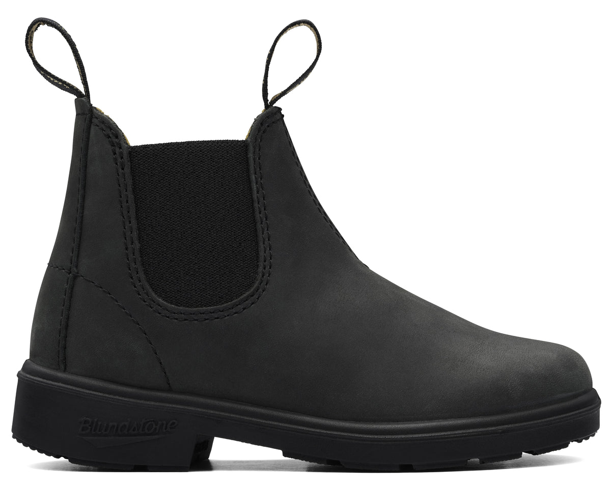 A black matte leather Chelsea boot featuring two fabric pull loops at the collar, an elastic side panel, and a thick, textured black rubber sole with the word Blundstone embossed on the heel.