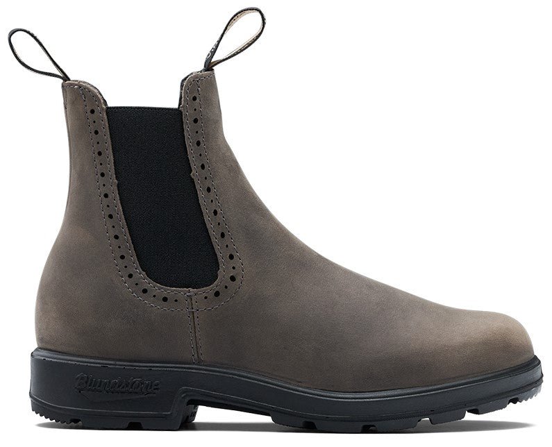 A gray leather Chelsea boot with a black elastic side panel featuring decorative brogue-style perforations along the edges and a thick, black lugged sole with the brand name stamped on the heel.