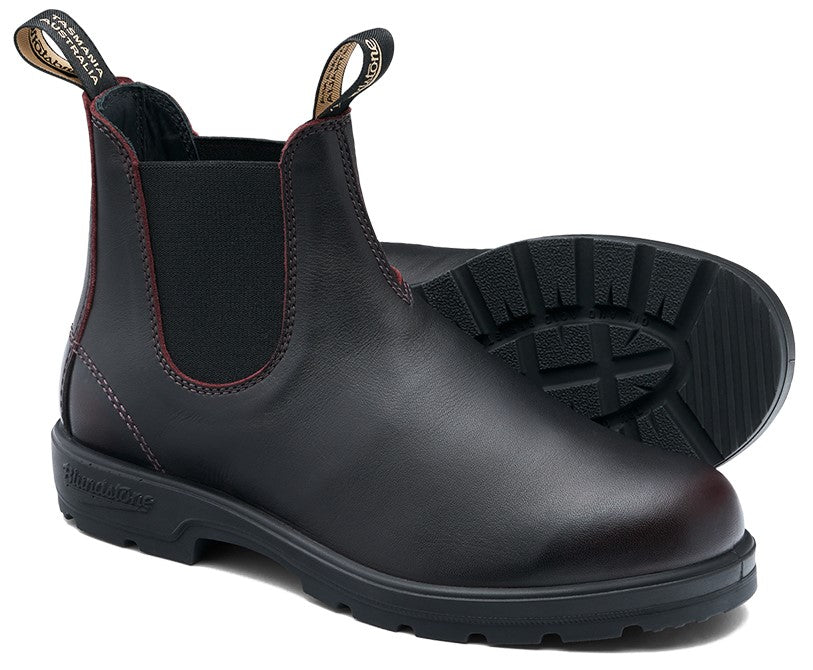 A black leather Chelsea boot with dark red stitching, elastic side panels, and black pull tabs labeled Tasmania Australia on a lugged rubber sole.