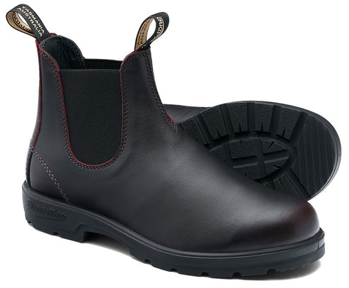 A black leather Chelsea boot with dark red stitching, elastic side panels, and black pull tabs labeled Tasmania Australia on a lugged rubber sole.