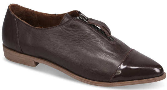 A dark brown leather flat shoe with a pointed toe, featuring a center front zipper closure and a low, light brown heel.