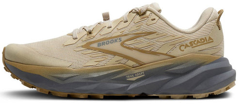 A tan running shoe with the word "BROOKS" and "CASCADIA" on the side, with a jagged gray and tan sole.