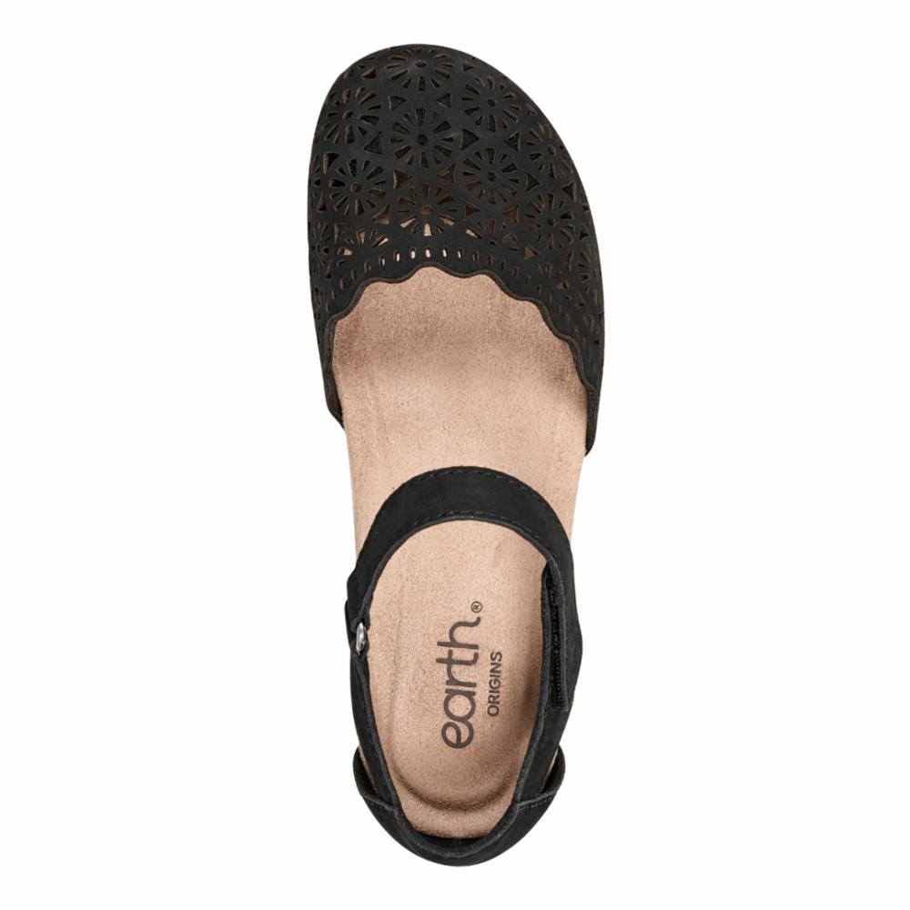 Black sandal with floral cutouts and an ankle strap.