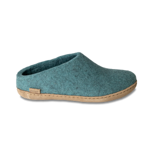 Close-up of a teal felt slipper with a tan sole.