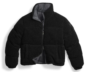 A black, cropped, puffer jacket made of textured, fleece-like material, featuring a high collar, long sleeves, and a central zipper closure that is partially open to reveal a grey interior lining.