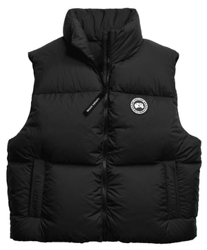 A black, sleeveless, quilted puffer vest with a high collar and a central full-length zipper featuring a black zipper pull with white text, featuring a round black and white logo patch on the left chest.