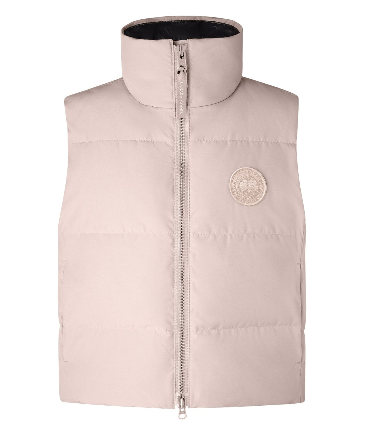 Sleeveless light-pink puffy jacket with a full zipper and a round logo patch.