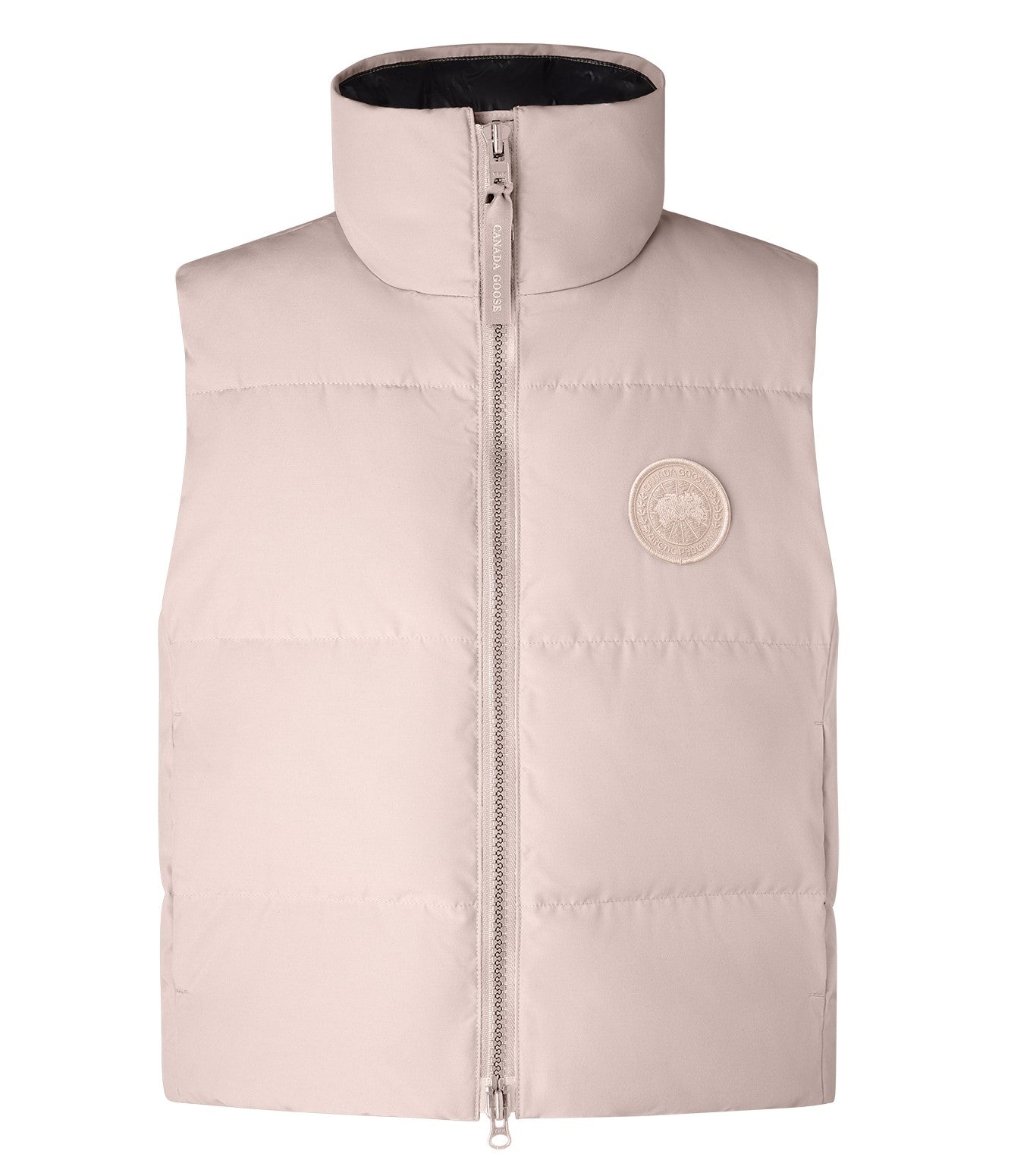 Sleeveless light-pink puffy jacket with a full zipper and a round logo patch.