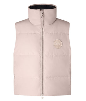 Sleeveless light-pink puffy jacket with a full zipper and a round logo patch.