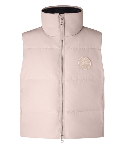 Sleeveless light-pink puffy jacket with a full zipper and a round logo patch.