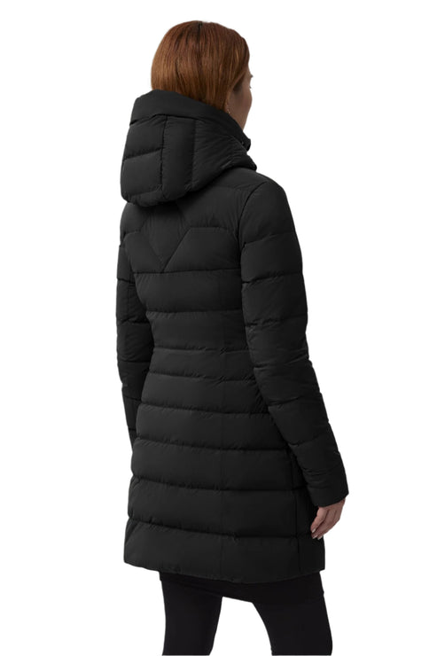 A person with red hair wears a long, black puffer coat with an attached hood and is facing away from the camera.