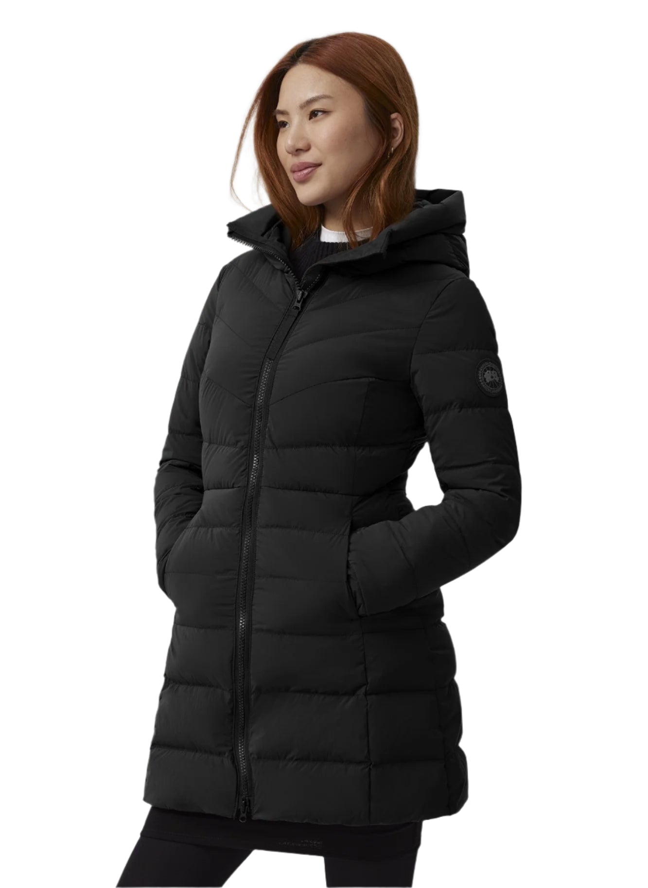 A woman in a black, mid-length, hooded puffer jacket with a zipper.