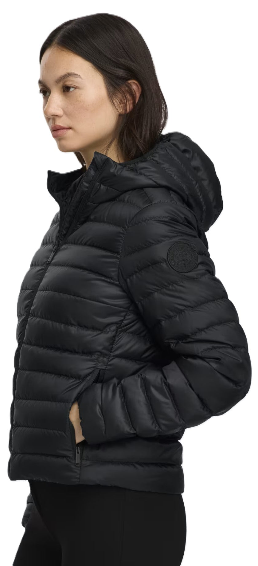 A woman wears a black puffer jacket with a hood.