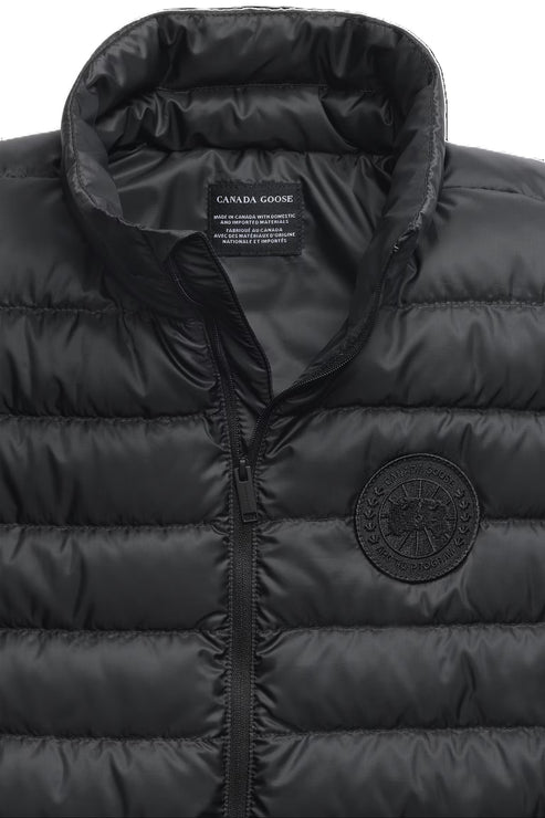 Close-up of a black puffer vest with visible zipper and the text "CANADA GOOSE".