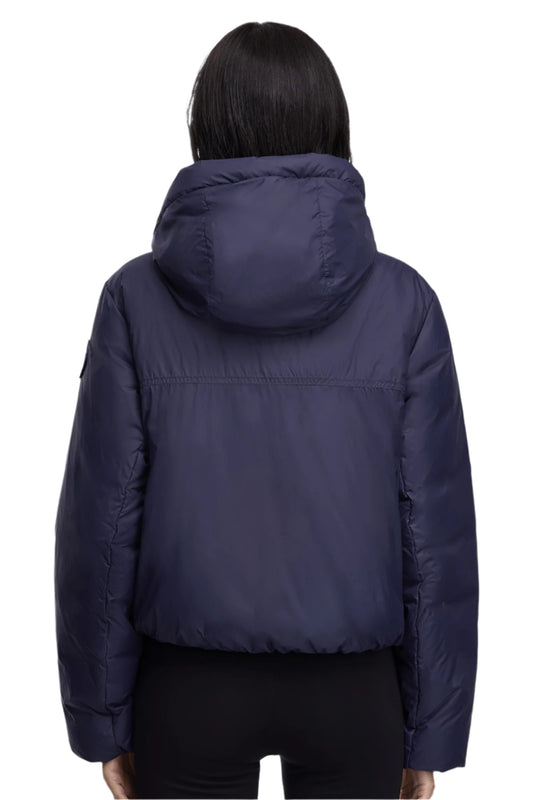 Back view of a woman wearing a navy hooded jacket.