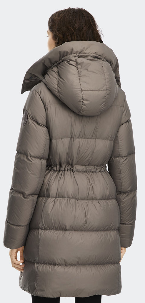 A woman with brown hair, wearing a gray puffer coat with a hood.