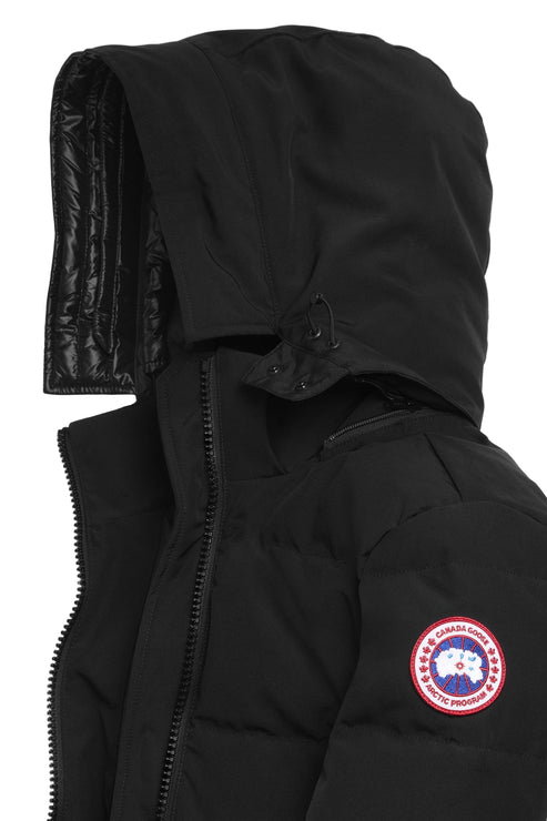 Close-up of black hooded puffer jacket with visible zipper, buttons, and circular emblem.