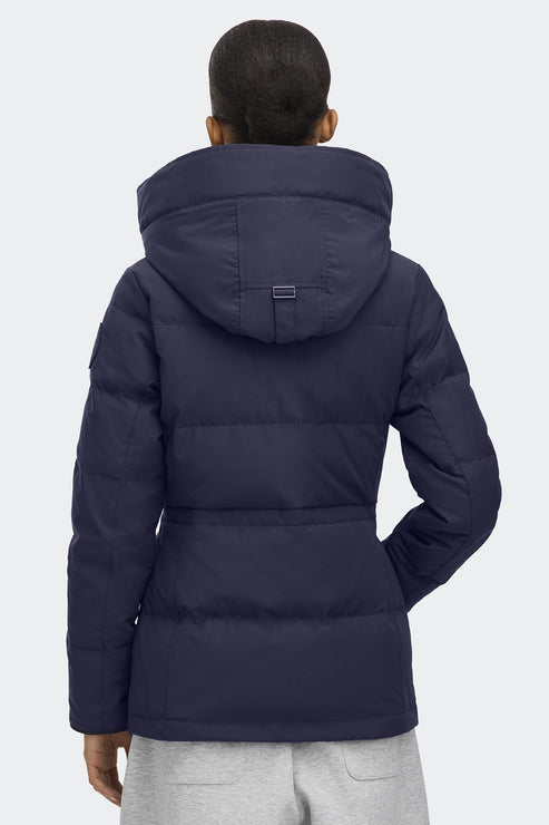 Back view of a woman wearing a navy blue, hooded, down-filled jacket.
