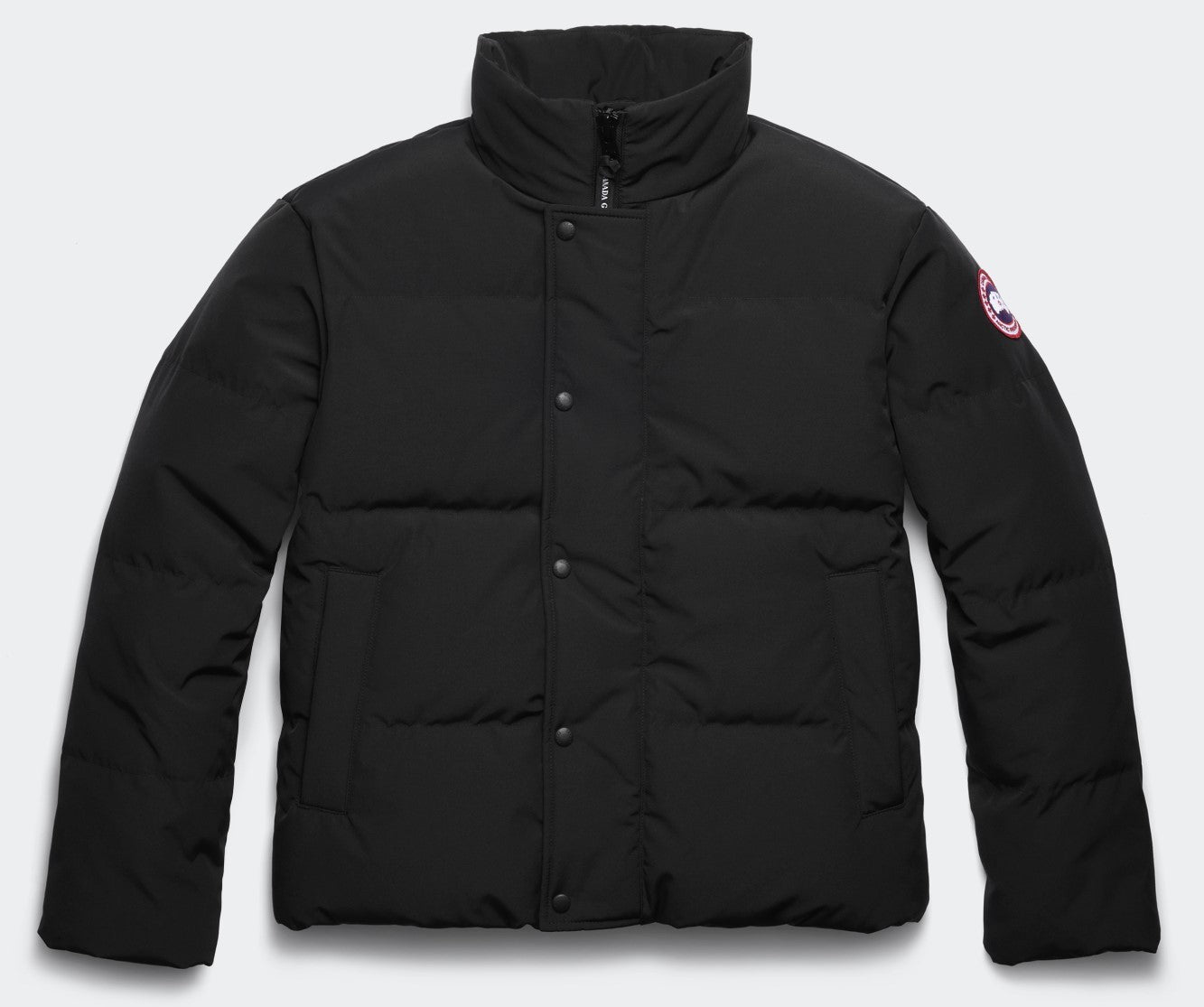 Black puffy jacket with a high collar and a circular patch on the right sleeve.
