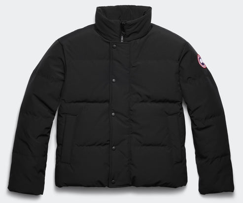 Black puffy jacket with a high collar and a circular patch on the right sleeve.