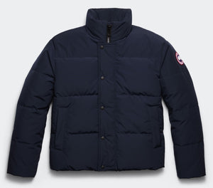 Navy blue puffer jacket with snap closure and circular logo on the sleeve.