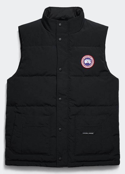 Black quilted down vest with stand collar, button closure, two front pockets, and a circular logo patch on the chest and the words "CANADA GOOSE" in white on the right.