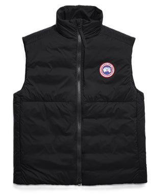 A black down-filled vest with a high collar and a circular patch on the chest.