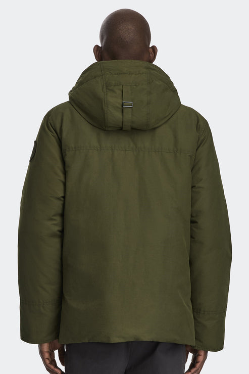 Rear view of a person wearing an olive green hooded winter jacket.