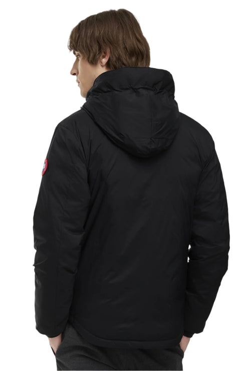 Back view of a person wearing a black winter jacket with a hood.
