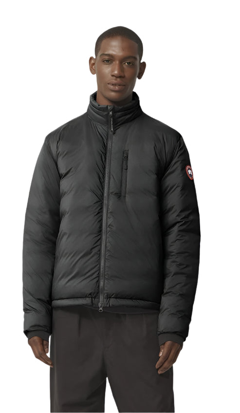 A black puffer jacket with a circular logo patch on the left sleeve, zipped up on a person.