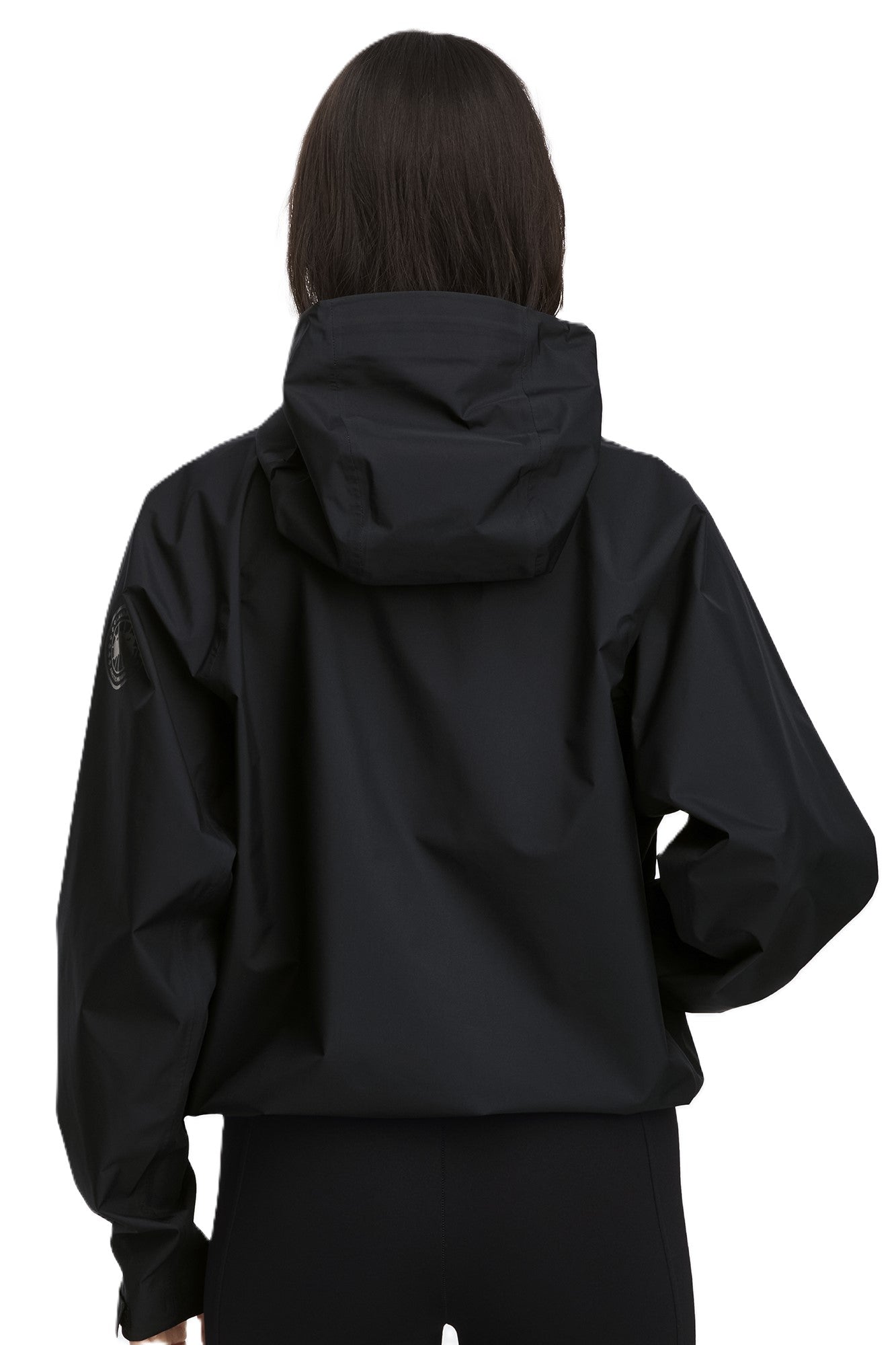Back view of a person wearing a black jacket with a hood.